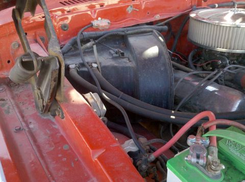 1979 Ford Bronco - Close-up view of an engine bay, showing the battery, air filter, and various hoses and wiring.