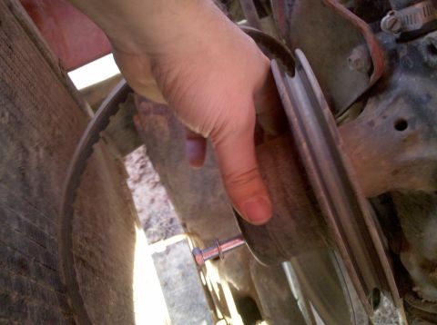 1979 Ford Bronco - A hand is shown adjusting a pulley and belt, likely during maintenance or installation.