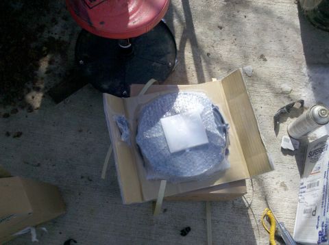 1979 Ford Bronco - A new brake rotor is shown unpacked on a concrete surface next to a can of spray lubricant.