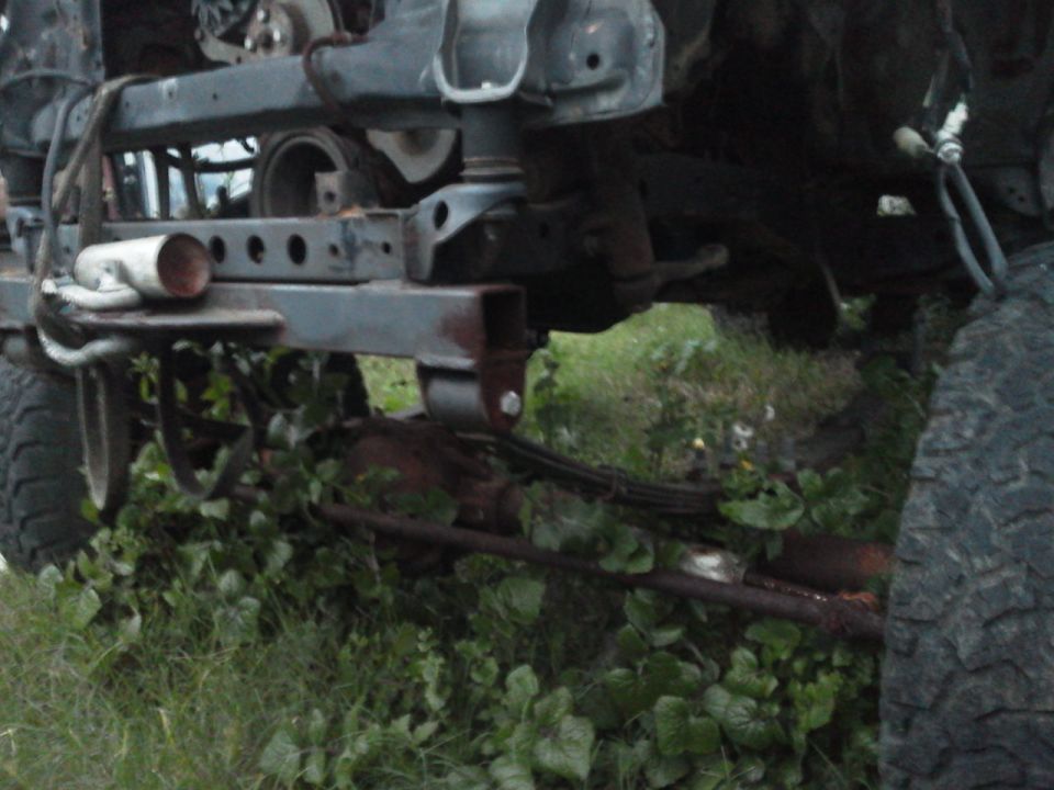 Undercarriage of a vehicle showing suspension components and frame. Tires are visible