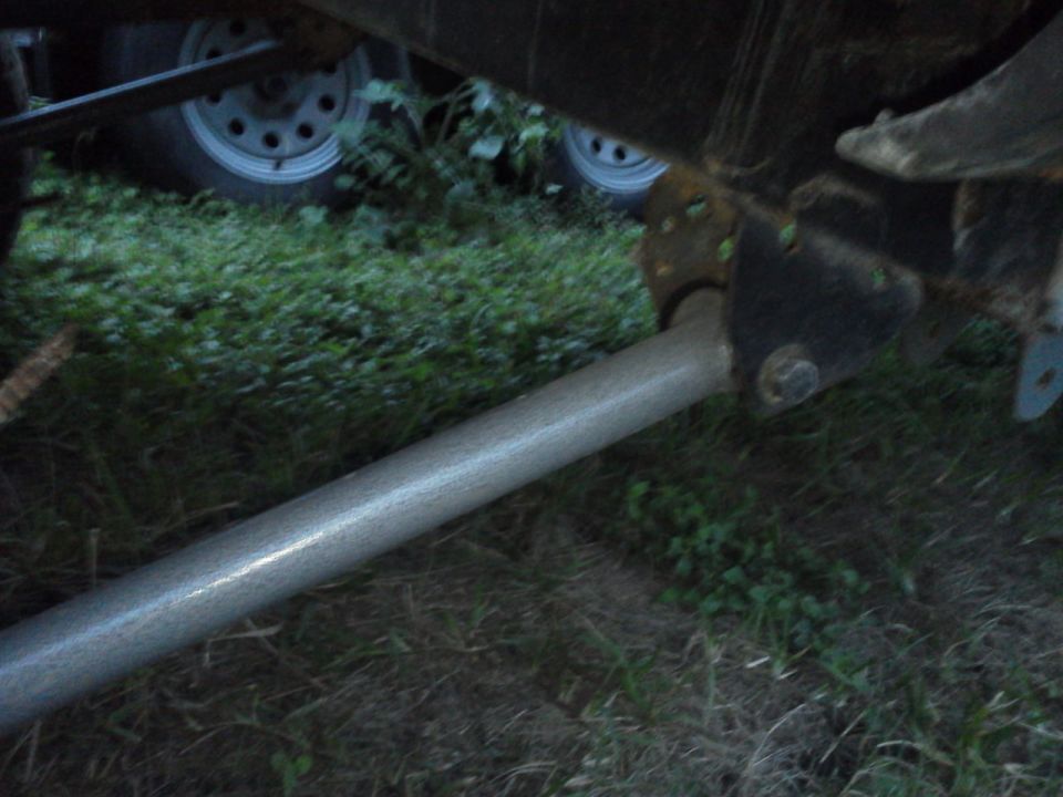 Trailer hitch assembly with suspension components and tires visible in grass