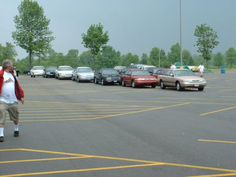 2000 Ford Crown Victoria - A line of cars in a parking lot, with a tan 2000 Ford Crown Victoria in the foreground.