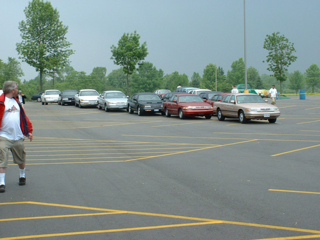 Gold Ford Crown Victoria leading a row of parked sedans at an outdoor car meet