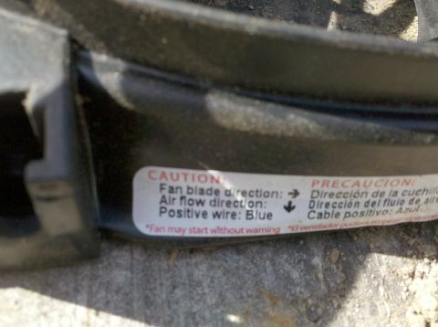 1979 Ford Bronco - A close-up of an electric fan shroud shows a caution label with installation instructions.