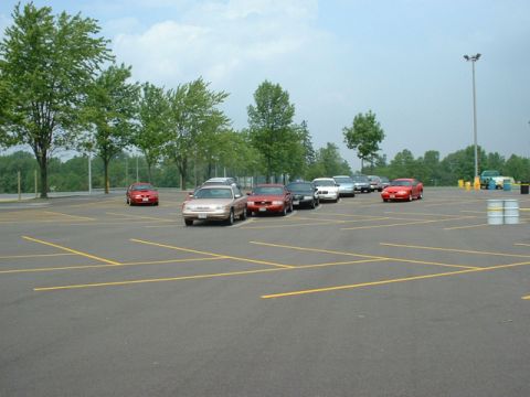 2000 Ford Crown Victoria - A parking lot scene with multiple vehicles, including a 2000 Ford Crown Victoria and a red Ford Mustang.