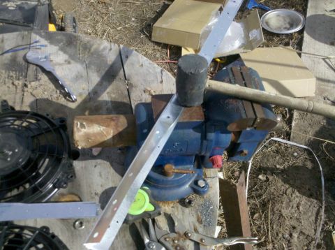 1979 Ford Bronco - An electric fan and a metal strip are clamped in a vise, suggesting a custom installation or repair.