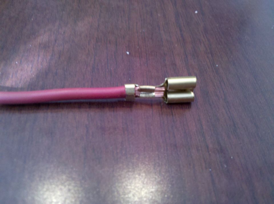 Electrical connector on a red wire, with Supermotors.net logo visible
