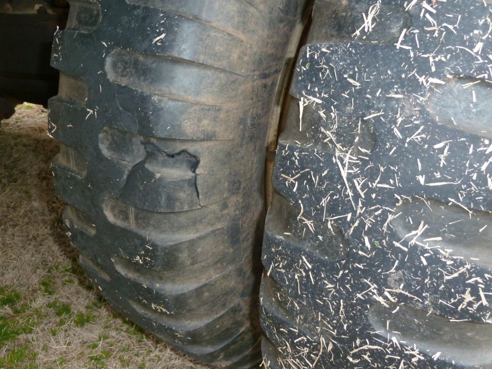 Damaged tire next to a clean tire, both with heavy tread