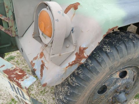 1992 Ford Mustang - Detail of a weathered truck showing rust damage on the fender, an orange headlight, and a tire.