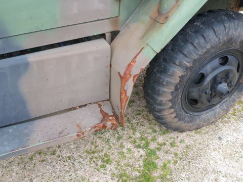 1992 Ford Mustang - Close-up of rust damage on a truck's fender and running board next to a flat tire.