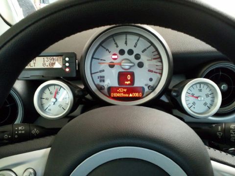 2010 MINI Cooper - Interior view of dashboard gauges, including a digital display showing temperature and mileage.