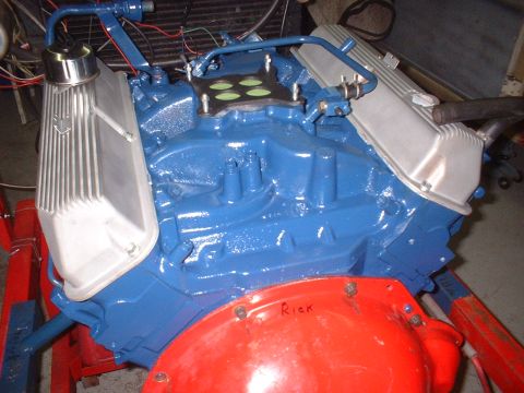 1969 Mercury Cyclone - A blue V8 engine is shown, possibly undergoing restoration or assembly, with a carburetor on top and aluminum valve covers.