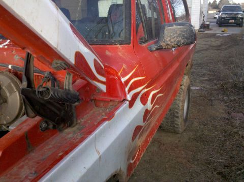 1979 Ford Bronco - Red SUV with flame decals and hood open, parked outdoors. Another vehicle is visible in the background.