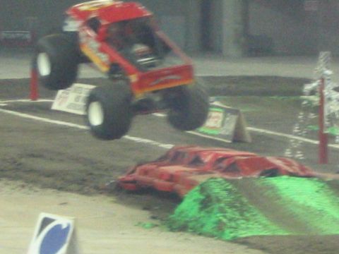 1986 Ford Bronco - A monster truck soars through the air during a competition.
