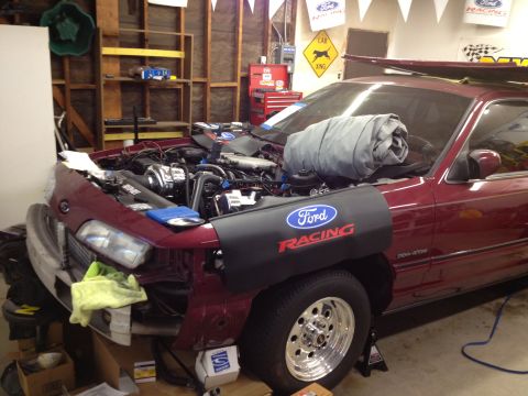 1992 Ford Crown Victoria - A maroon Ford Crown Victoria is in a garage with its hood open, revealing the engine bay. A Ford Racing fender cover is in place.