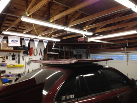 1992 Ford Crown Victoria - A maroon sedan's roof is covered by a detached panel, with Ford Racing banners visible in the background.