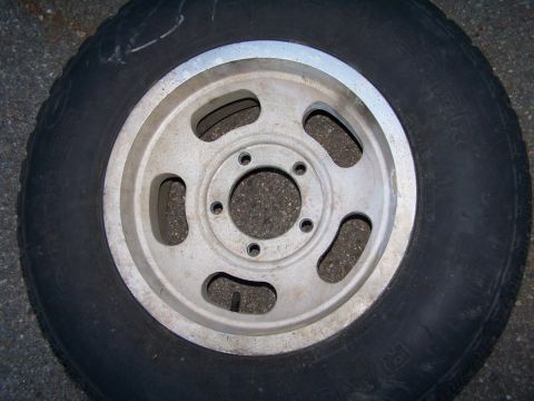 1973 Ford Bronco - A single tire and rim assembly is shown, resting on a textured surface.