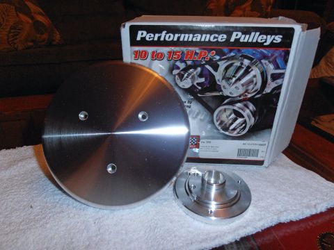 1990 Ford Bronco - A box of performance pulleys is shown next to two metal components, possibly for a vehicle.