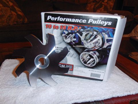 1990 Ford Bronco - A metal fan blade and a box for performance pulleys are displayed on a white towel.