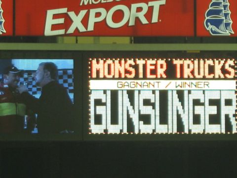 1986 Ford Bronco - A scoreboard displays the winner of a monster truck event as 'Gunslinger'.