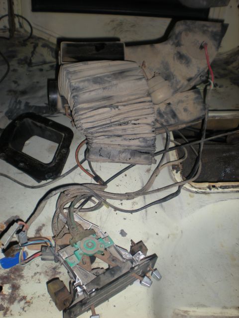 1978 Ford Bronco - Disassembled heating system components, including a blower motor housing and control assembly with wiring, are shown.