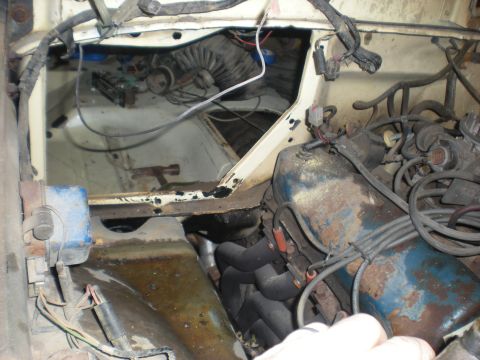 1978 Ford Bronco - The engine bay of a vehicle shows various mechanical parts and wiring, with signs of wear and tear.