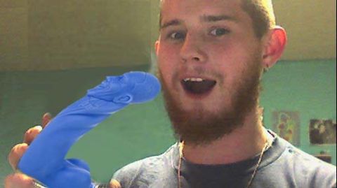 1970 Mercury Cougar - A person holds up a blue dildo with a face sculpted onto the head.