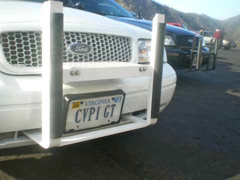 2004 Ford Crown Victoria - A white Ford Crown Victoria, possibly a police vehicle, is parked outdoors with a push bar and Virginia license plates.