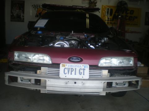 2004 Ford Crown Victoria - Front view of a red car with its hood open, revealing the engine and intercoolers.
