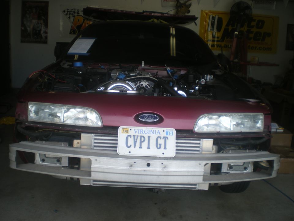 Red car front view with hood open, intercoolers visible