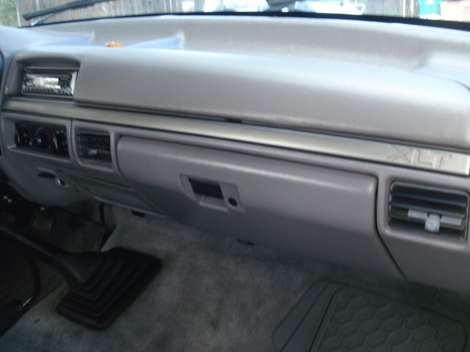 Interior shot of a truck's dashboard, showing the glove box, radio, and air vents. XLT trim is visible