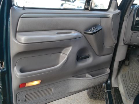 1994 Ford F-250 - Interior view of a truck door panel, showing gray plastic trim and a door handle.