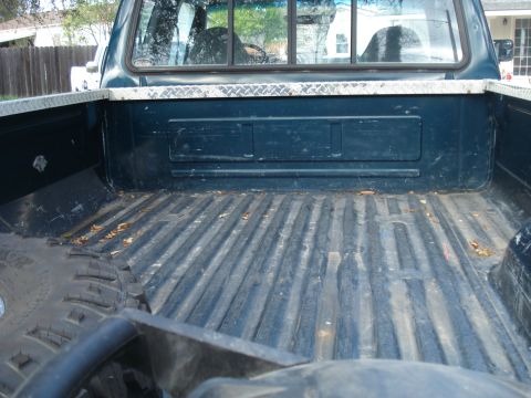 1994 Ford F-250 - The bed of a dark blue 1994 Ford F-250 pickup truck features diamond plate trim along the top edge.