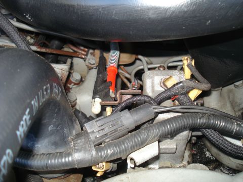 1994 Ford F-250 - A close-up view of various engine components, including hoses and wiring harnesses, in a vehicle's engine bay.