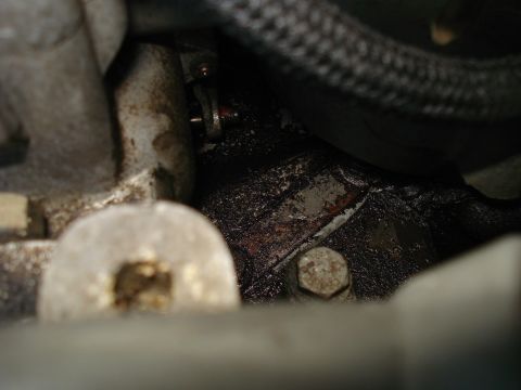 1994 Ford F-250 - A close-up view of an engine part shows an oil leak and a braided hose.