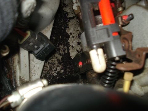 1994 Ford F-250 - Close-up view of engine components, including electrical connectors and a spring.