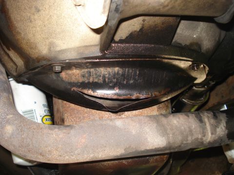 1994 Ford F-250 - Close-up view of the undercarriage, revealing an oil filter and exhaust system components.