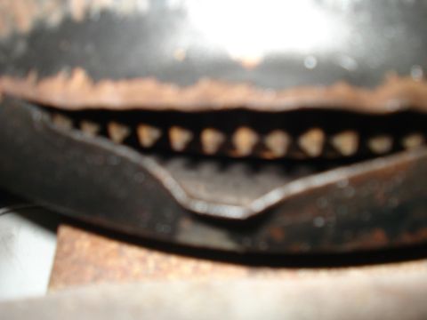 1994 Ford F-250 - A close-up view of a vehicle's grille section, showing rust and a series of openings.