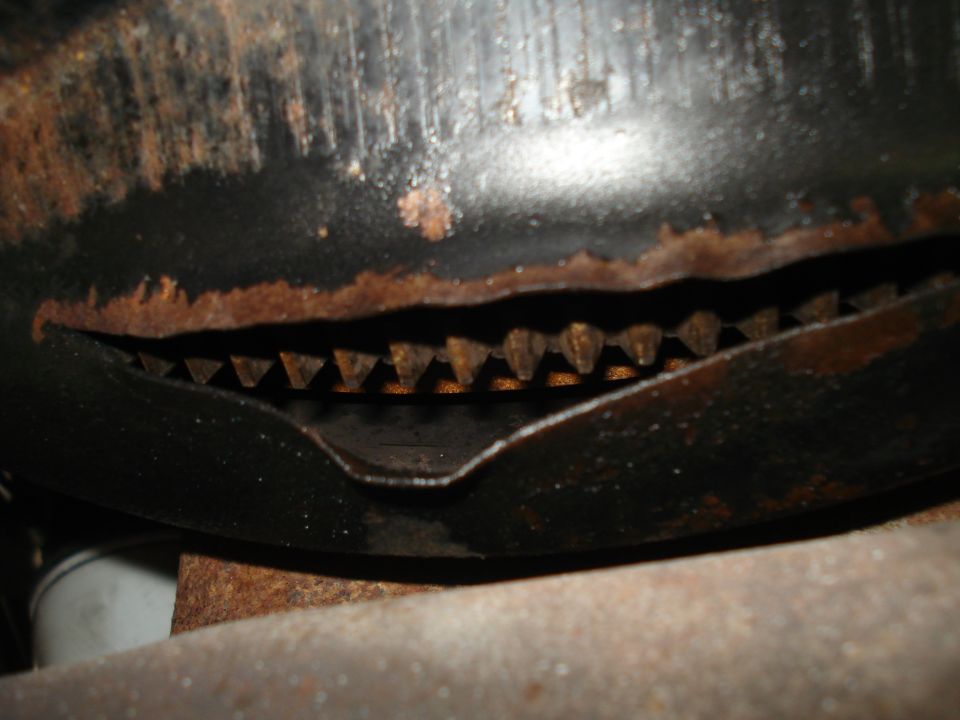 Close-up of rusted metal part with visible teeth and a Supermotors.net watermark