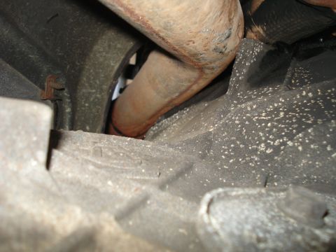 1994 Ford F-250 - Underside view of vehicle exhaust pipe and transmission housing.