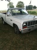 1985 Dodge Dakota - This white Dodge pickup truck is shown from the front 3/4 angle, parked outdoors on a grassy area.