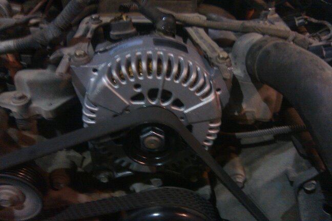 Close-up of car engine alternator with serpentine belt