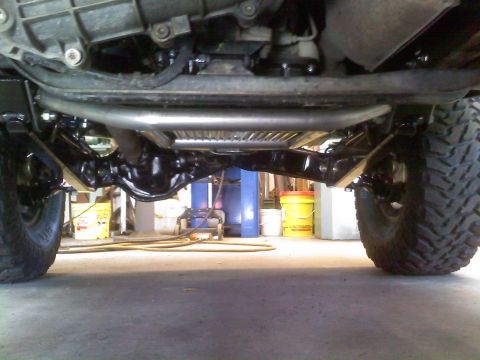 1996 Ford Bronco - Close-up view of the undercarriage and suspension system of a vehicle, highlighting its robust build.