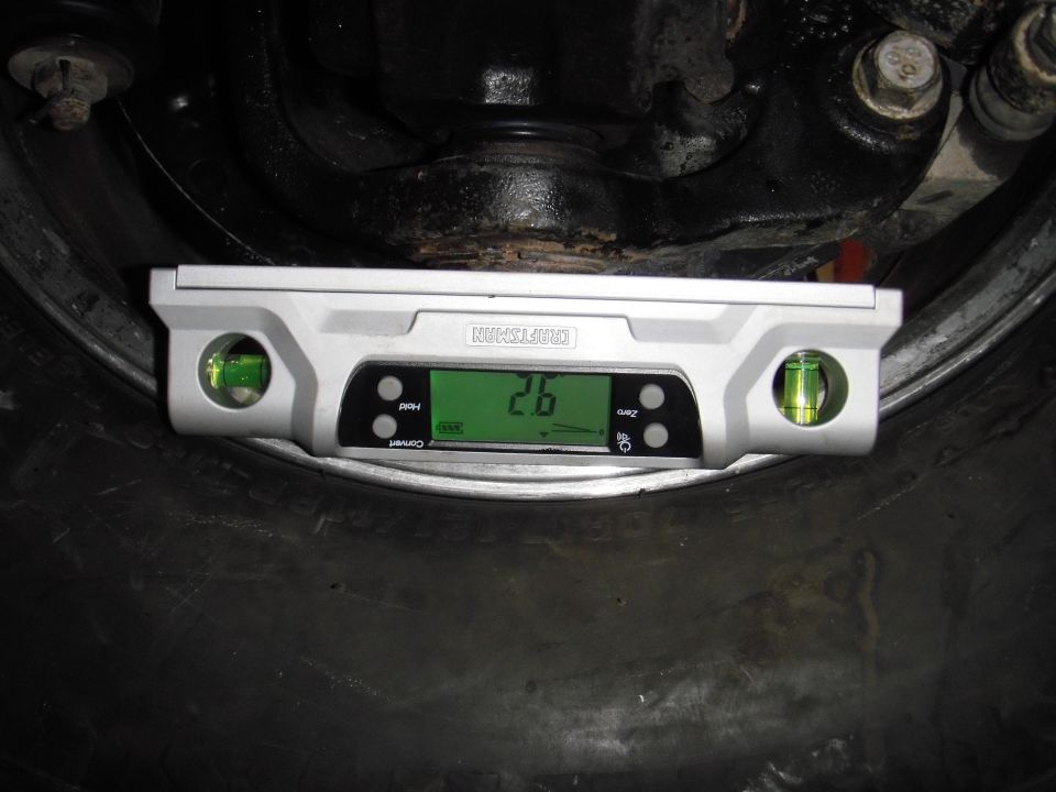 Digital level showing 2.6 degrees on a dark tire with visible suspension components