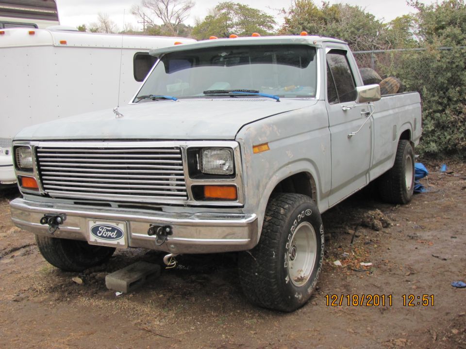 Light-colored pickup truck with chrome grille and Ford badge. Visible date stamp 12/18/2011