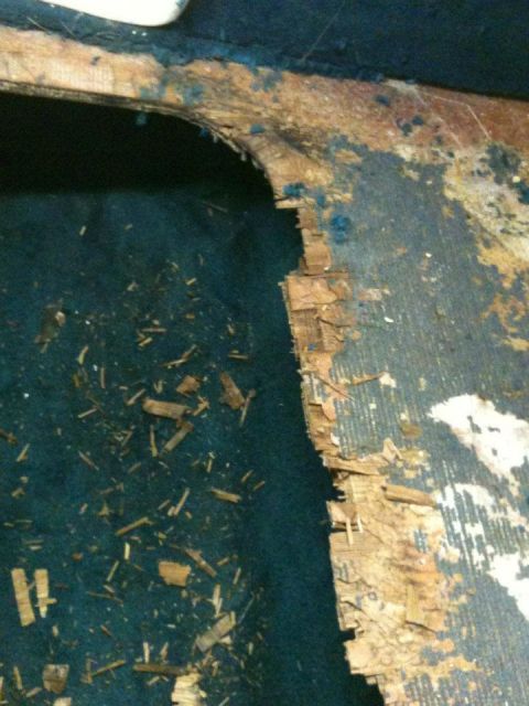 1978 Chevrolet Camaro - Close-up of damaged interior paneling with debris scattered on the blue carpet.
