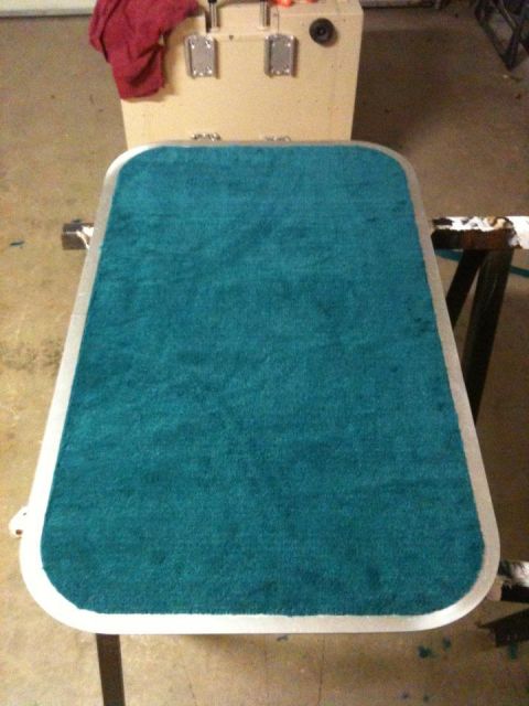 1978 Chevrolet Camaro - Carpeted panel with metal trim, likely an interior part, seen in a workshop setting.