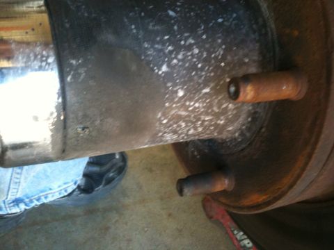 1995 Ford Bronco - Close-up of a vehicle's rear axle and brake drum assembly, showing rust and wear.
