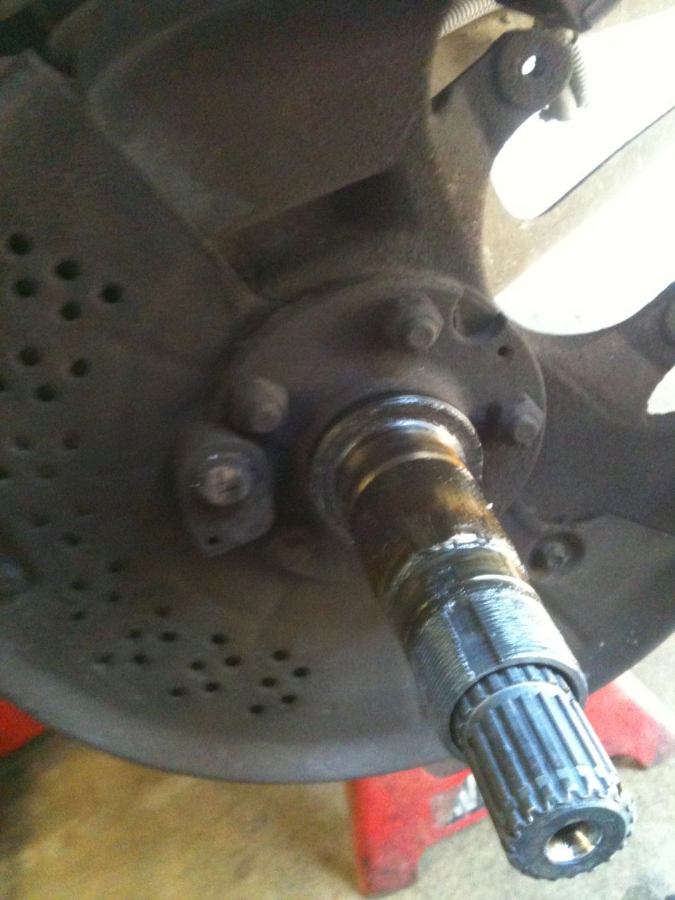Close-up of a vehicle's front wheel hub assembly with splined axle shaft