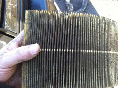 1997 Ford F-250 - Dirty air filter being held by a hand.